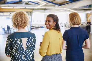 Portrait smiling businesswoman walking in office - HOXF03055