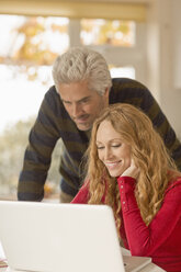 Couple using laptop at home - HOXF03120