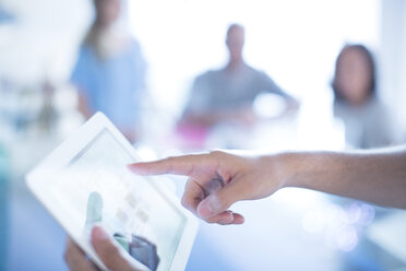 Close up businessman pointing to digital tablet in meeting - HOXF03143