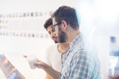 Creative graphic designers with coffee discussing proofs stock photo