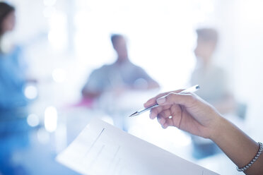 Close up businesswoman holding pen reviewing paperwork - HOXF03169