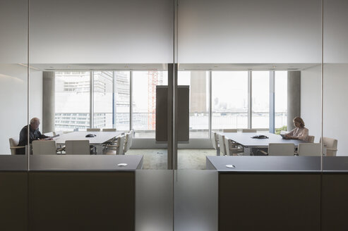 Geschäftsleute arbeiten in modernen, symmetrischen Konferenzräumen - HOXF03201