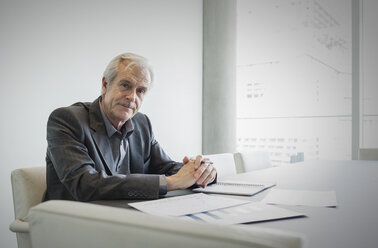 Portrait confident senior businessman working in conference room - HOXF03230