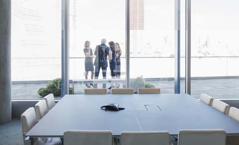 Geschäftsleute im Gespräch auf dem Balkon eines Konferenzraums, lizenzfreies Stockfoto