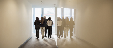 Geschäftsleute gehen im Bürokorridor, lizenzfreies Stockfoto