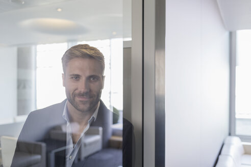 Porträt selbstbewusster Geschäftsmann am Fenster im Konferenzraum - HOXF03255