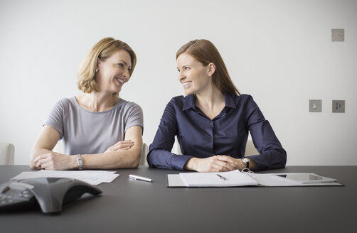 Lächelnde Geschäftsfrauen bei einer Besprechung - HOXF03260