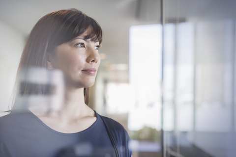 Pensive businesswoman looking out window stock photo