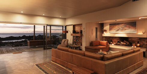 Home showcase interior living room overlooking ocean at sunset - HOXF03304