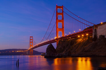 Low angle view of illuminated Golden Gate Bridge against blue sky - CAVF00001