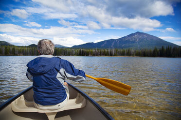 Rear view of man boating in lake towards mountain - CAVF00015