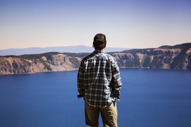 Rückansicht eines Mannes mit Blick auf einen See bei klarem Himmel - CAVF00052