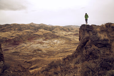 Frau steht auf einer Klippe vor Bergen - CAVF00096