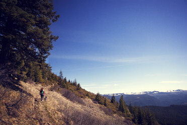Hohe Winkel Ansicht der Wanderer mit Hund auf Berg gegen blauen Himmel gehen - CAVF00140