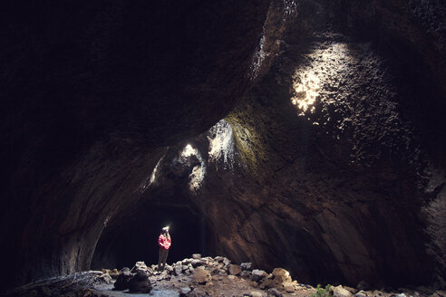 Frau steht in einer Oberlichthöhle an einem sonnigen Tag - CAVF00147