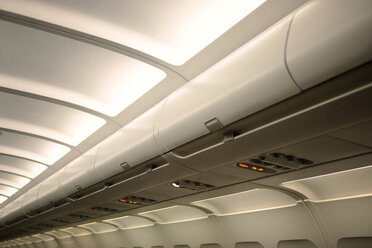 Niedriger Blickwinkel auf Gepäckfächer in einem beleuchteten Flugzeug - CAVF00159