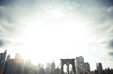 Niedriger Winkel Blick auf Brooklyn Bridge und Stadtbild gegen bewölkten Himmel - CAVF00166