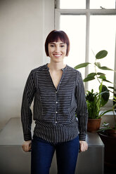 Portrait of happy confident woman standing in creative office - CAVF00338