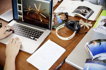 Ausgeschnittenes Bild einer Geschäftsfrau, die an einem Laptop am Schreibtisch arbeitet - CAVF00346