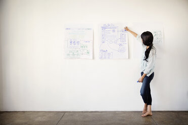 Businesswoman drawing on chart in office - CAVF00348