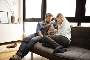 Familie sitzt auf der Couch im Wohnzimmer - CAVF00416