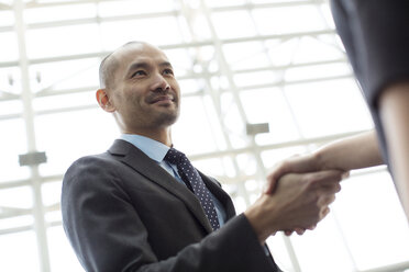 Business people shaking hands in office - CAVF00437