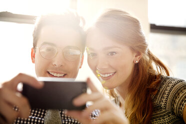 Geschäftskollegen machen ein Selfie mit dem Smartphone im Büro - CAVF00445