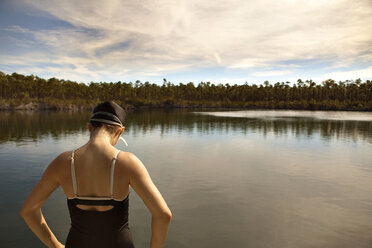 Rückansicht einer Frau in Badekleidung, die am See steht - CAVF00476