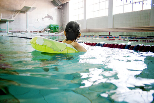 Junge mit aufblasbarem Ring schwimmt im Pool - CAVF00559