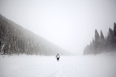 Rückansicht eines Wanderers auf einem schneebedeckten Feld - CAVF00594