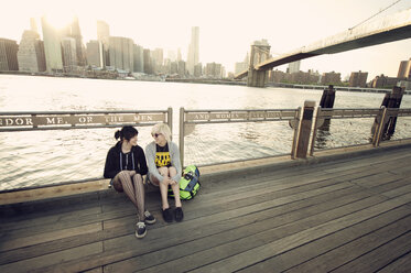Glückliche Freunde ruhen sich auf der Promenade am East River in der Stadt aus - CAVF00629