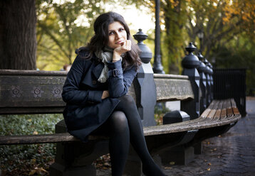 Portrait of smiling woman sitting on bench in Central Park - CAVF00704