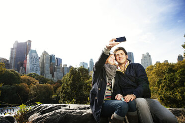 Happy couple taking selfie in Central Park on sunny day - CAVF00708