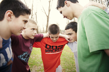 Boys forming huddle while standing on field in match - CAVF00722