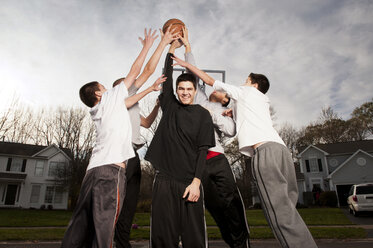 Glückliche Jungen spielen Basketball auf der Straße - CAVF00728
