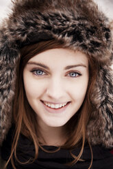 Close-up portrait of happy woman wearing fur hat - CAVF00739