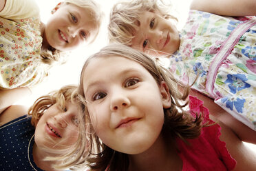 Low angle view of girls huddling on sunny day - CAVF00845