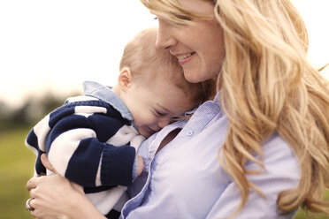 Close-up of smiling mother holding baby outdoors - CAVF00848