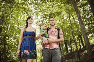 Niedriger Blickwinkel einer Familie, die beim Spaziergang im Wald wegschaut - CAVF00928