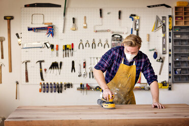 Männlicher Schreiner bei der Bearbeitung von Holz in einer Werkstatt - CAVF01037