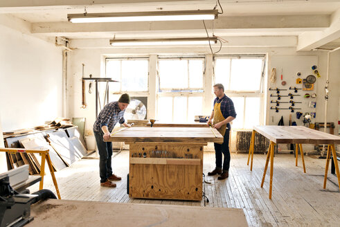 Männliche Zimmerleute arbeiten an einer Holzkonstruktion in einer Werkstatt - CAVF01041