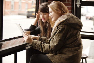 Freundinnen benutzen ein digitales Tablet im Cafe - CAVF01063