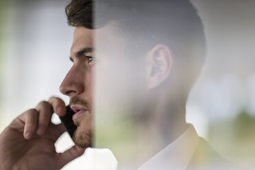 Close up profile serious businessman talking on smart phone, looking away - CAIF04602