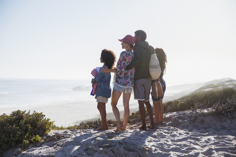 Familie mit Blick auf die Aussicht auf einen sonnigen Sommerstrand, lizenzfreies Stockfoto