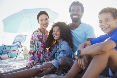 Porträt einer lächelnden, glücklichen multiethnischen Familie am Sommerstrand, lizenzfreies Stockfoto