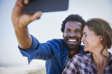 Zärtliches, glückliches multiethnisches Paar macht Selfie mit Fotohandy - CAIF04788