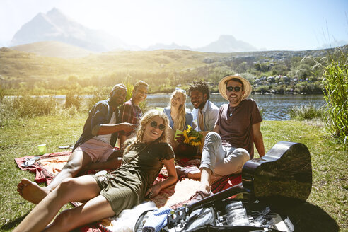 Porträt lächelnd junge Freunde hängen, genießen Picknick an sonnigen Sommer Flussufer - CAIF04794