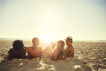 Young couples laying, relaxing on sunny summer beach - CAIF04795