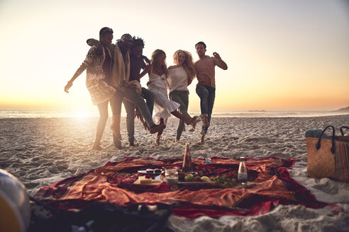 Verspielt junge Freunde treten, genießen Picknick auf sonnigen Sommer Sonnenuntergang Strand - CAIF04808