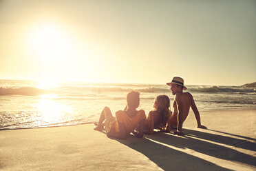 Junge Freunde entspannen sich am idyllischen, sonnigen Sommerstrand bei Sonnenuntergang - CAIF04814